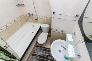 La salle de bains est pourvue d'une baignoire, de toilettes et d'un lavabo. dans l'établissement Книжный Город, à Almaty