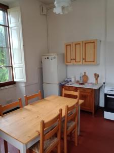 una cucina con tavolo in legno e frigorifero di Casa con Vista - Border House - Pontremoli a Pontremoli