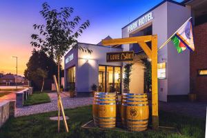 a wine store with two barrels in front of it at Park Hotel Bük-Bükfürdő in Bük