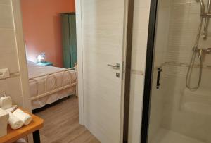 uma casa de banho com um chuveiro e um quarto com uma cama em Le Acacie em Torreano