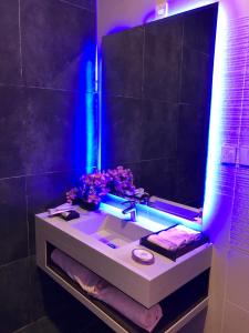 a bathroom with a sink with a blue light at Dana Hotel in Buraydah