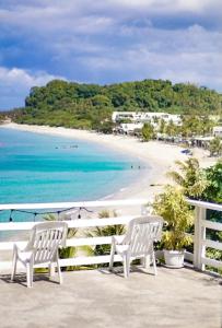 two white chairs sitting on a balcony overlooking a beach at Playa Blanca Beach Resort in Puerto Galera +79 photos