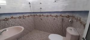 a bathroom with a toilet and a bath tub at Paradise inn in Kamburagalla
