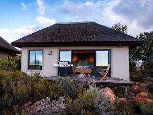 una piccola casa con terrazza e tavolo di Rooilande Guest Farm a Laingsburg