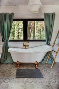 a bath tub in a bathroom with trees at Wiejskie Swawole-domki w lesie na wsi 