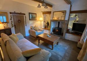 sala de estar con sofá y chimenea en Bluebell Cottage, en Grassington
