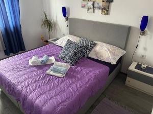 a bedroom with a purple bed with shoes on it at Apartment Marina in Senj