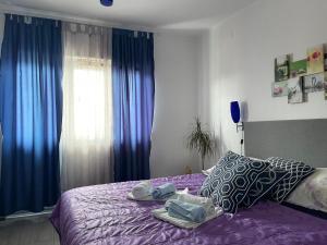 a bedroom with a purple bed with blue curtains at Apartment Marina in Senj