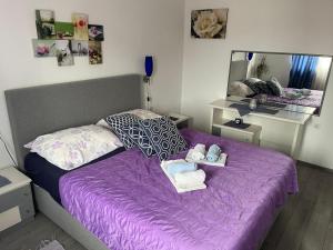 a bedroom with a purple bed with towels and a mirror at Apartment Marina in Senj