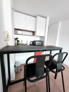 a black desk with a chair in a kitchen at Studio Chacabuco in Córdoba