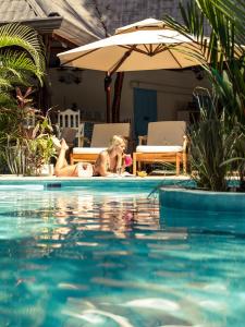 una mujer tendida al lado de una piscina en Hotel Guiones, en Nosara