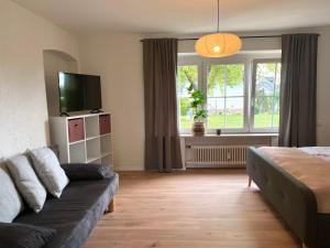 ein Wohnzimmer mit einem Sofa und einem TV in der Unterkunft Kelsbachhaus EG in Pförring