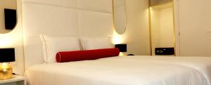 a bedroom with a white bed with a red pillow at Lisbon City Hollywood Hotel by City Hotels in Lisbon