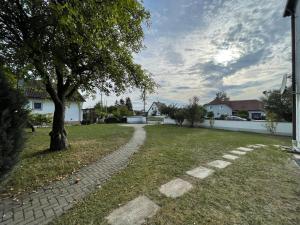 a brick path in a yard with a tree at Kelsbachhaus EG in Pförring