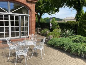 a patio with a table and chairs in a garden at Landhausidyll Ferienwohnung in Grundshagen