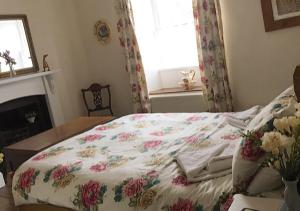 Una cama con una manta floral en un dormitorio en Bluebell Cottage, en Grassington