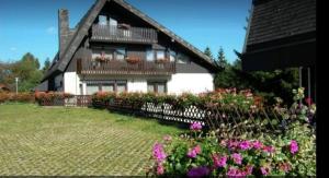 una casa con dei fiori davanti di Ferienhaus-Schönwald im Herzen des Schwarzwaldes 2-Zimmer mit Terrasse und Whirlpool App15 a Schönwald Altre 8 foto