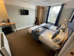 a hotel room with two beds and a window at The George Hotel in Whitby