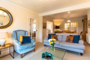 uma sala de estar com duas cadeiras azuis e um sofá em Finest Retreats - Tideway em Saint Clement
