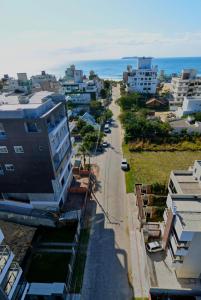 una vista aérea de una ciudad con edificios y el océano en Hospeda Mariscal Flat en Bombinhas