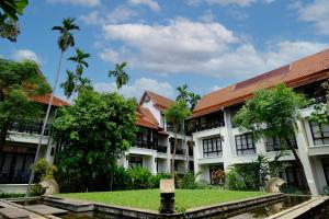 a courtyard of a building with palm trees at Bodhi Serene, Chiang Mai - SHA Extra Plus in Chiang Mai