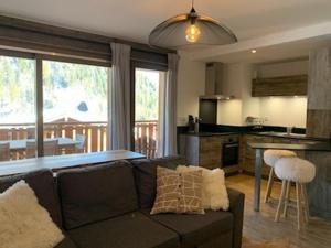 ein Wohnzimmer mit Couch und Küche in der Unterkunft Charmant appart 4 pers avec balcon, parking & WiFi - FR-1-198-211 in Châtel + 7 Fotos