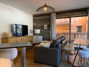 ein Wohnzimmer mit Sofa und Fernseher in der Unterkunft Charmant appart 4 pers avec balcon, parking & WiFi - FR-1-198-211 in Châtel