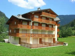 a large building with balconies on top of a field at Appartement Châtel, 2 pièces, 2 personnes - FR-1-198-221 in Châtel