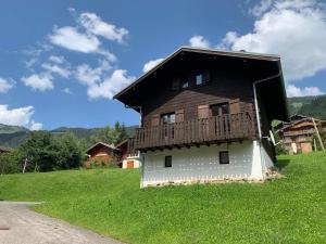 a house with a balcony on the side of a field at Chalet Châtel, 5 pièces, 8 personnes - FR-1-198-220 in Châtel