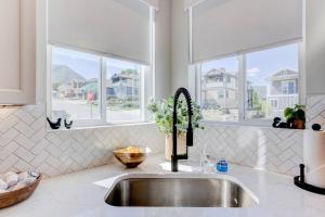 a kitchen counter with a sink and two windows at Midway to Heaven! BRAND NEW 5 bed 4.5 bath, HOTTUB in Midway +73 photos