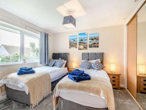 two beds in a room with two windows at Oystercatcher in Drummore