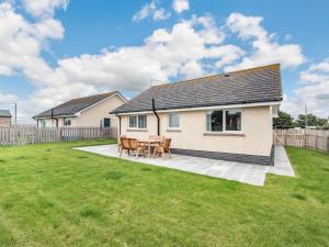 ein Haus mit einem Tisch und Stühlen im Hof in der Unterkunft Oystercatcher in Drummore