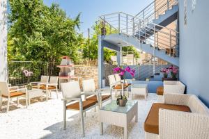 a patio with chairs and tables and a staircase at New Azzurro Deluxe in Limenaria