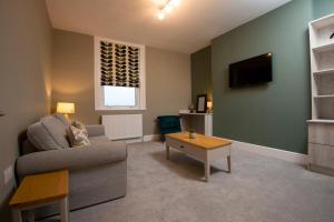 a living room with a couch and a tv at Amadeus Apartments in Douglas