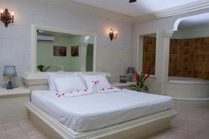 1 Schlafzimmer mit einem weißen Bett und einer Badewanne in der Unterkunft Aparthotel Castillo Real in Punta Cana