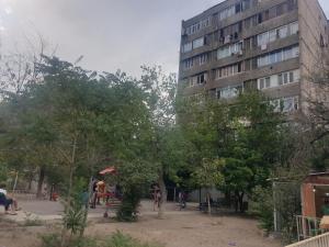 Sunny Apartment close to Erebuni mall في يريفان: مبنى طويل مع أشخاص يجلسون حول حديقة