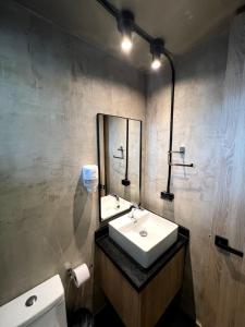 La salle de bains est pourvue d'un lavabo, d'un miroir et de toilettes. dans l'établissement Hotel D' Leon, à Bucaramanga