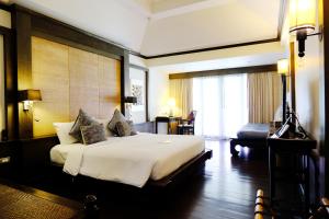 ein Hotelzimmer mit einem großen Bett und einem Schreibtisch in der Unterkunft Bodhi Serene, Chiang Mai - SHA Extra Plus in Chiang Mai