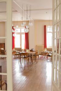 uma sala de jantar com mesa, cadeiras e janelas em Best Western Grand Hotel de Paris em Villard-de-Lans