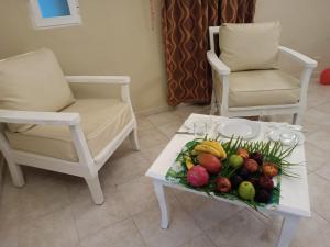 蓬塔卡納的住宿－Aparthotel Castillo Real，一张桌子、一个水果盘和两把椅子