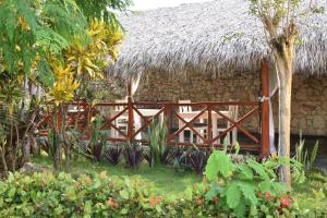 a fence in front of a building with a thatch roof at Aparthotel Castillo Real in Punta Cana