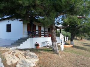 a house with stairs and a table and a tree at House lagonisi in Ormos Panagias