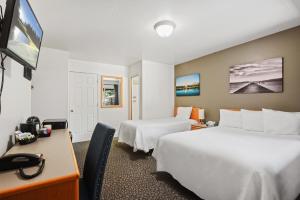 a hotel room with two beds and a desk at Crown Motel in Kings Beach