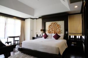 um quarto com uma grande cama branca com almofadas vermelhas em Bodhi Serene, Chiang Mai - SHA Extra Plus em Chiang Mai