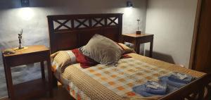 una camera da letto con un letto con due tavoli e un cuscino di Karallantay a Tilcara
