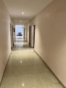 an empty hallway with white walls and a tile floor at HOTEL THILAK in Tuticorin