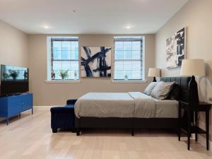 a bedroom with a bed and a tv and windows at Stay at Luna on Callowhill in Philadelphia