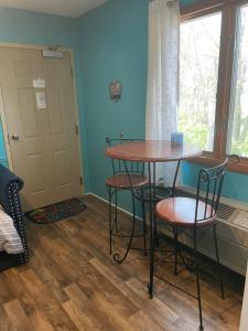 Zimmer mit einem Tisch, Stühlen und einem Fenster in der Unterkunft Lake Point Motel in Marblehead