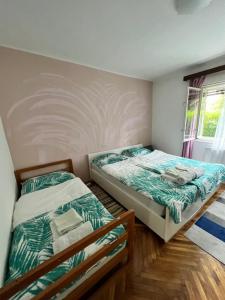 a bedroom with two beds and a window at Rooms & Apartments MURGLE Ljubljana in Ljubljana