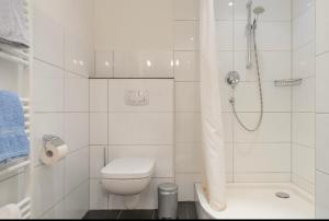 a white bathroom with a toilet and a shower at Haus Kleemann in Norderney